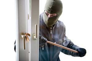 Einbrecher dringt in ein Haus ein in dem er das Fenster aufhebelt.